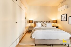 A bedroom with a bed, bedside lamps, a radiator, and a wardrobe. - Penthouse With Magical Acropolis View & Jacuzzi! (Athina)