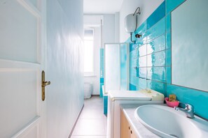 A bathroom with a white sink, a mirror, and blue tiles. - Oasis Flat Near San Gregorio Armeno (Naples)