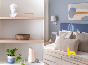 A bedroom with a bed, pillows, a bedside table with a lamp, and a wall-mounted artwork. - Athenian Retreat near Acropolis! (Athina)