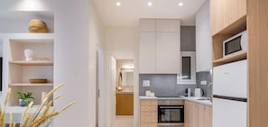 A modern kitchen with built-in appliances, wooden cabinets, and a central island. - Koukaki Elegance Athenian Retreat near Acropolis! (Athina)