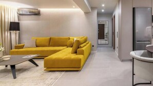 A modern living room with a sectional sofa, a coffee table, and a lamp. - Premium Retreat w/ Patio, Parking & Acropolis View (Athina)