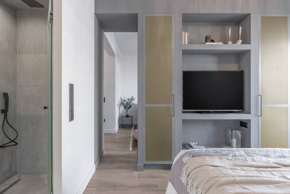 A modern hotel room with a large bed, a television, and a walk-in closet with a mirror. - 50 Shades of Athens, Kingsize suite with Jacuzzi! (Athina)