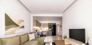 Un salon moderne comprenant un canapé, un téléviseur à écran plat et un coin repas avec des chaises et une table.