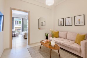 Uma sala de estar moderna com um sofá, uma mesa de centro e quadros nas paredes.