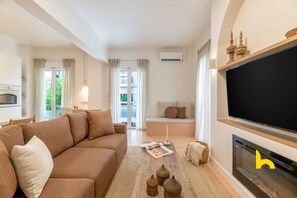 Ein modernes Wohnzimmer mit einer Couch, einem Kamin und einem Fernseher.