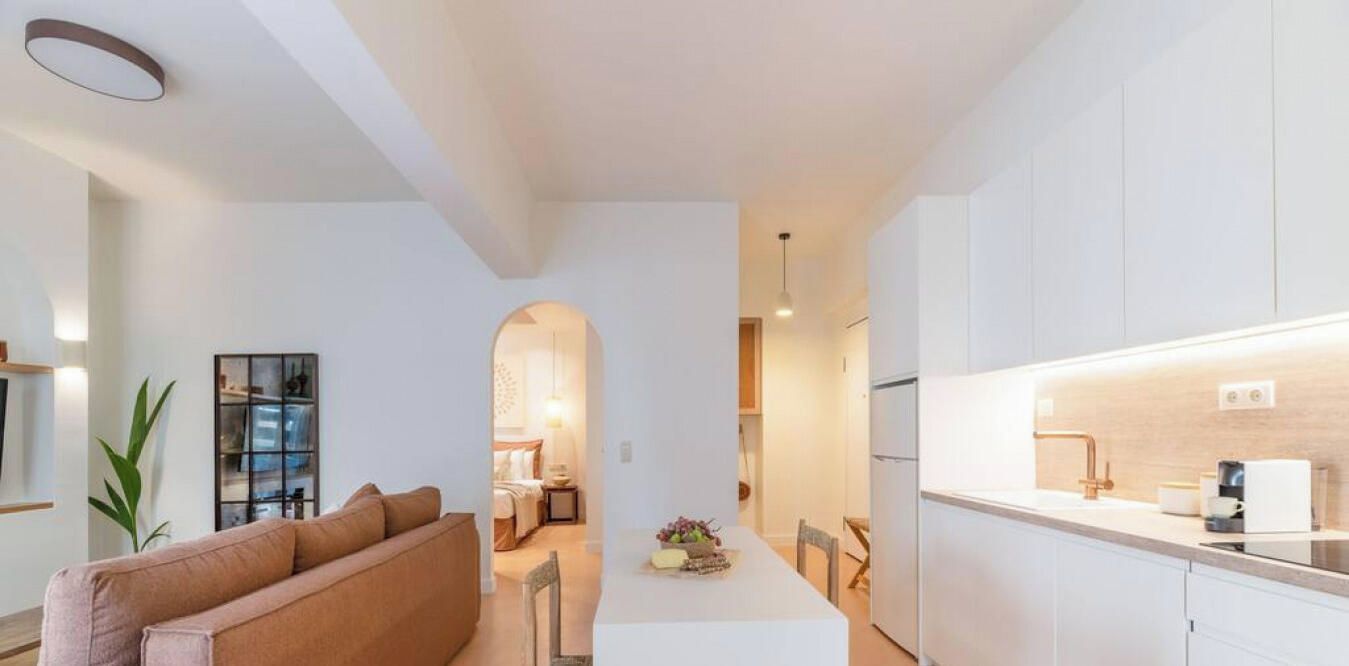 A modern apartment with a living area, kitchen, and dining space.
