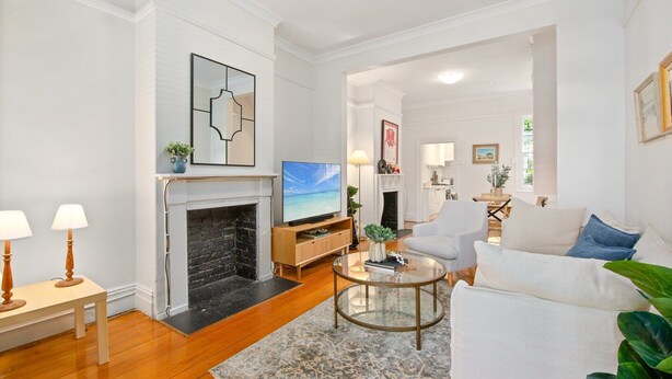 Una sala de estar con chimenea, televisor, sofá y una mesa de centro.