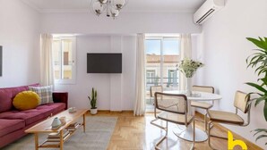 Ein modernes Wohnzimmer mit einer Couch, einem Couchtisch und einem Essbereich mit Stühlen.