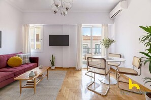 Ein modernes Wohnzimmer mit einer Couch, einem Couchtisch und einem Essbereich mit Stühlen.