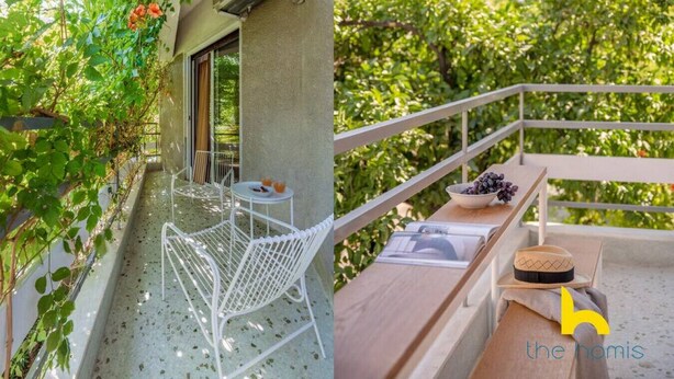 Ein Balkon mit weißem Metallstuhl und -tisch, einer Schale Trauben und einer Holzkiste.