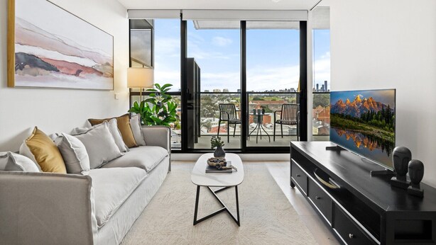 A modern living room with a sofa, coffee table, and TV. There is a balcony with a city view. - South Yarra Stay with Balcony Views (South Yarra)