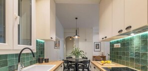 Une cuisine avec un îlot central, un évier et une table à manger.