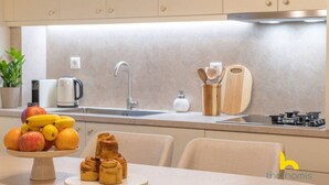 Una cocina moderna con un lavamanos, estufa y un frutero sobre la encimera.