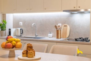 Eine moderne Küche mit Spüle, Herd und Obstschale auf der Arbeitsfläche.
