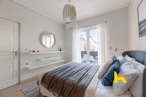A modern bedroom with a bed, a bedside table, a mirror, and a view of the outside. - Sunny Athenian Oasis Spacious Family Haven! (Kallithea)