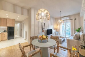 Eine moderne Wohnung mit Essbereich, Küche, Wohnzimmer und großen Fenstern.