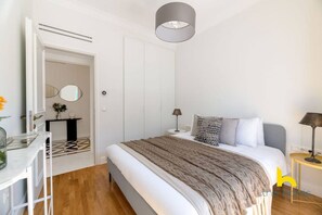 Une chambre moderne avec un grand lit, des tables de chevet, un bureau et une armoire.