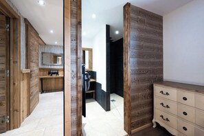 A room with wooden paneling, a mirror, a dresser, and a bench. - Chalet Les Papis ⭐ Heated Pool • Sauna • Lake View • Gérardmer (Gérardmer)