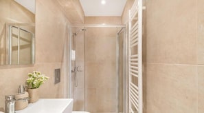 A modern bathroom with a glass-enclosed shower, a white sink, and a towel rack. - Rooftop Hideaway w/ Large Private Patio near Metro (Athina)