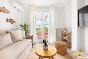 A modern living room with a sofa, a round coffee table, and a potted plant. - Rooftop Hideaway w/ Large Private Patio near Metro (Athina)