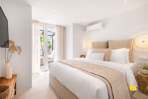 A modern bedroom with a large bed, a flat-screen TV, and a sliding glass door leading to an outdoor area. - Rooftop Hideaway w/ Large Private Patio near Metro (Athina)
