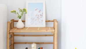 A bamboo shelf with a framed picture and a white vase with flowers. - Rooftop Hideaway w/ Large Private Patio near Metro (Athina)
