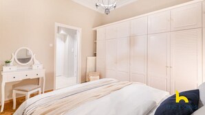 Une chambre à coucher comprenant un lit, une commode, un miroir et une armoire.