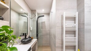A modern bathroom with a white vanity, a black sink, a glass shower enclosure, and a white towel rack. - The Urban Jungle Escape Corner APT Near Acropolis (Athina)