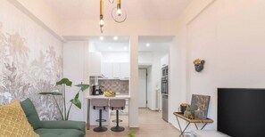 A modern living room with a green sofa, a TV, and a plant. - The Urban Jungle Escape Corner APT Near Acropolis (Athina)