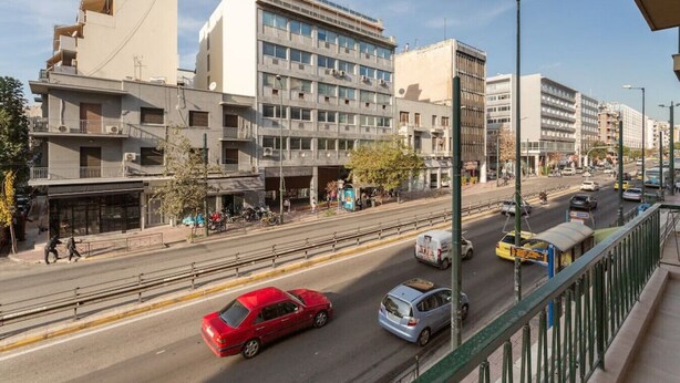 Una vista di strada con edifici, una carreggiata e veicoli.