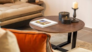 Un tavolino rotondo con una rivista, una candela e contenitori decorativi.