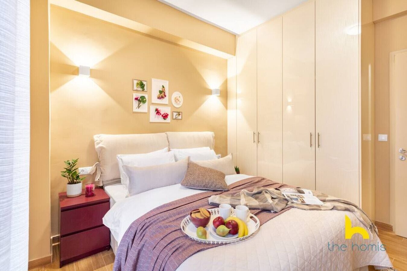 Ein modernes Schlafzimmer mit Bett, Nachttischen, einem Kleiderschrank und Wandleuchten.