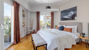 Un dormitorio moderno con una cama grande, un escritorio y vistas al exterior.