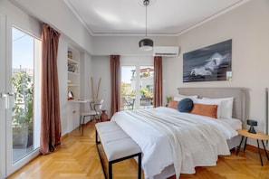 Ein modernes Schlafzimmer mit einem großen Bett, einem Schreibtisch und Blick ins Freie.
