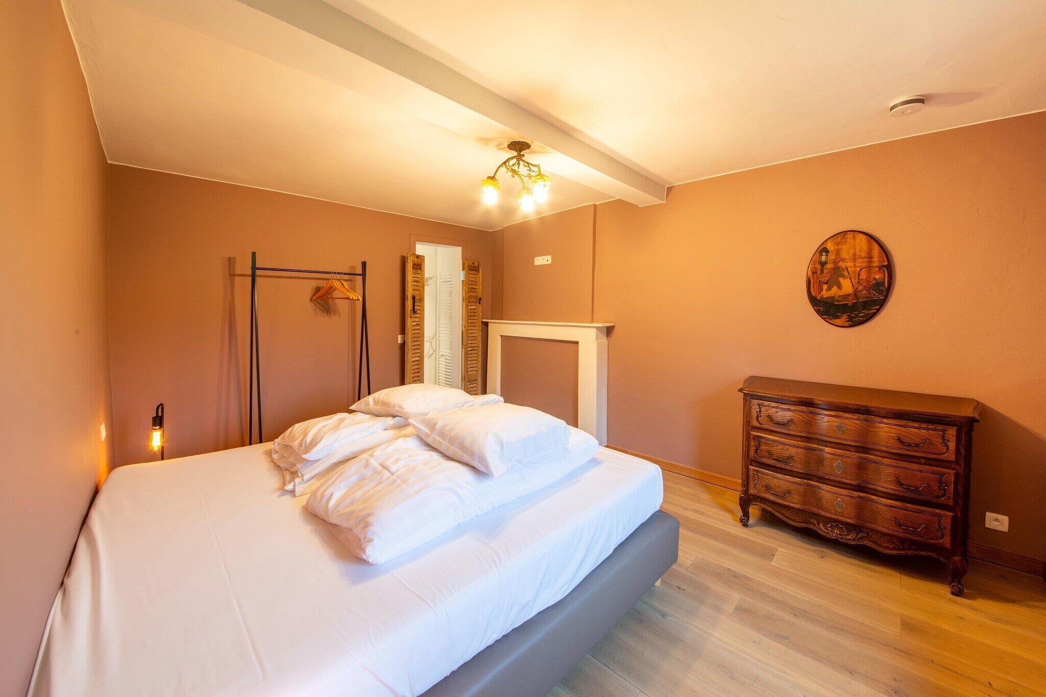 Un dormitorio con cama, cómoda y espejo.