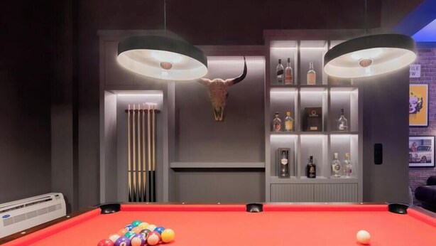 A pool table with balls, a bull's head decoration, and a shelf with bottles. - Unique Urban Cave w/ Pool Table Near Acropolis! (Athina)