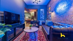 A modern living room with a pool table, leather sofa, and a neon sign. - Unique Urban Cave w/ Pool Table Near Acropolis! (Athina)
