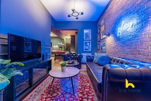 A modern living room with a pool table, leather sofa, and a neon sign. - Unique Urban Cave w/ Pool Table Near Acropolis! (Athina)