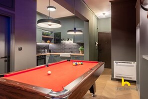 A pool table with balls, a kitchen area, and a modern interior design. - Unique Urban Cave w/ Pool Table Near Acropolis! (Athina)