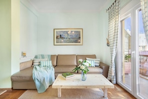 Ein Wohnzimmer mit einem beigefarbenen Sofa, einem Couchtisch und einem Bild an der Wand.
