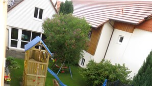 A backyard with a wooden play structure, a trampoline, and a small garden area. - Apartment 1 with Terrace, Garden and Wi-Fi (Überlingen)