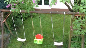A wooden swing set with two swings, one green and one white, suspended by ropes. - Apartment '3' with Balcony, Garden and Wi-Fi (Überlingen)