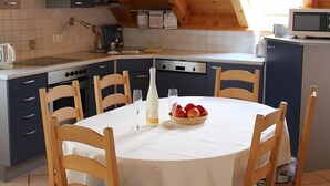 A kitchen with a dining table set for two, a microwave, and a sink. - Apartment '3' with Balcony, Garden and Wi-Fi (Überlingen)