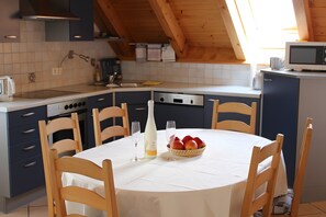 Une cuisine équipée d’une table à manger pour deux personnes, d’un four à micro-ondes et d’un évier.