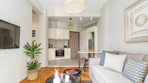 Een moderne woonkamer met een bank, salontafel en een eethoek met een tafel en stoelen.