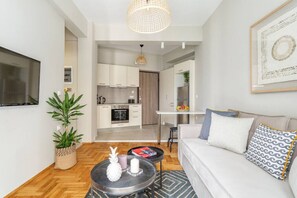 A modern living room with a sofa, coffee table, and a dining area with a table and chairs. - Discover Athens from Urban Hideaway,Acropolis View (Athina)