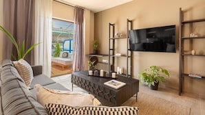 A modern living room with a sofa, coffee table, and TV. There is a balcony with a view. - Acropolis View, Minimal-Safari Vibe, Big Balcony! (Athina)