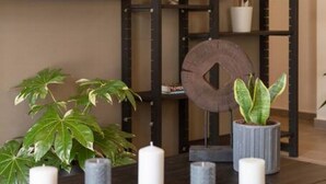 A dark wooden shelf with potted plants and candles. - Acropolis View, Minimal-Safari Vibe, Big Balcony! (Athina)