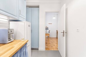 A compact kitchen with a microwave, a refrigerator, and a wooden countertop. - Chill Out In Retropolitan Hideaway at Alsos Park (Athina)