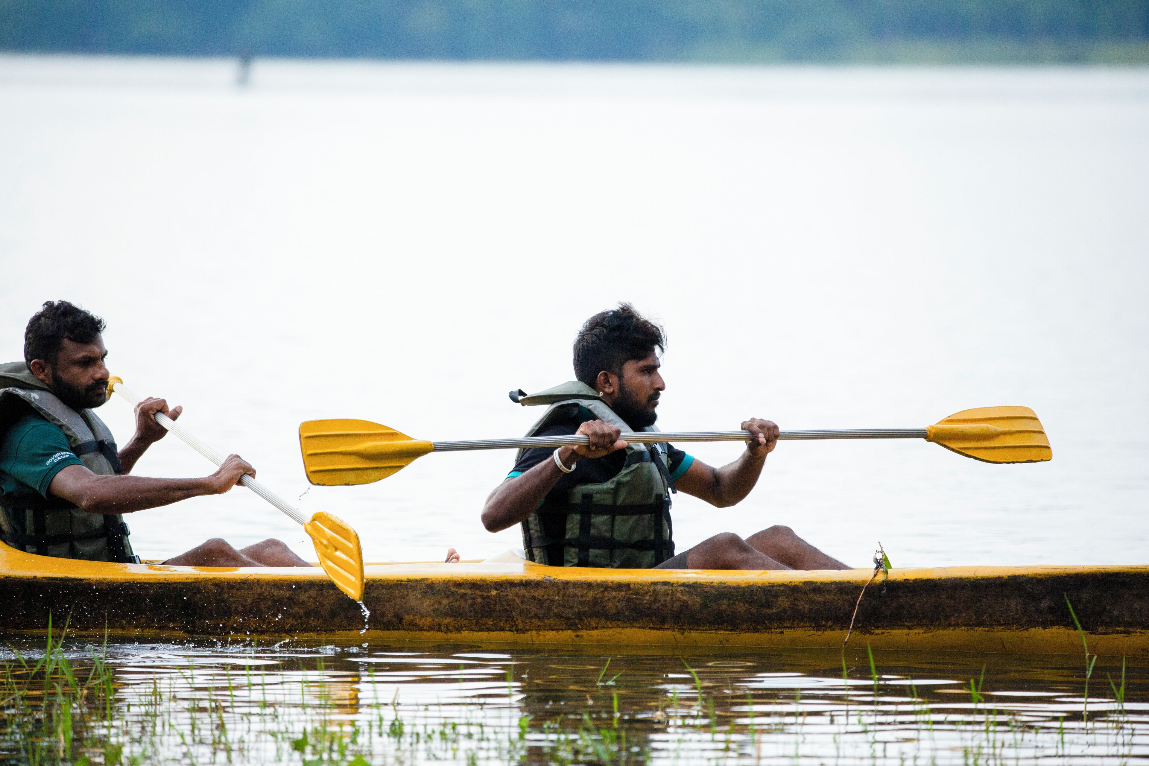 Due persone in un canoa gialla su un'acqua calma.